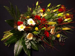 rouwboeket liggend , gerbera, lelie , roos, groensoorten, craspedia